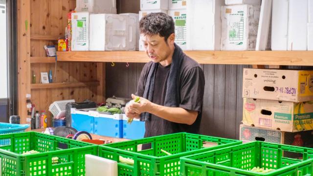 収穫したアスパラガスを束ねる永田さん